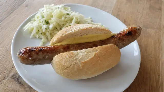 Bratwurst im Brötchen auf einem Teller