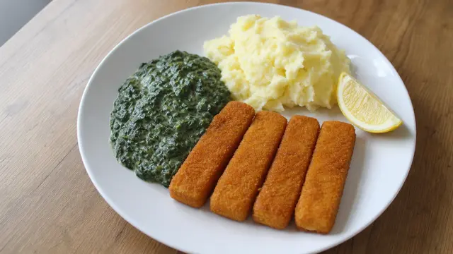 Fischstäbchen mit Kartoffelpüree auf einem Teller