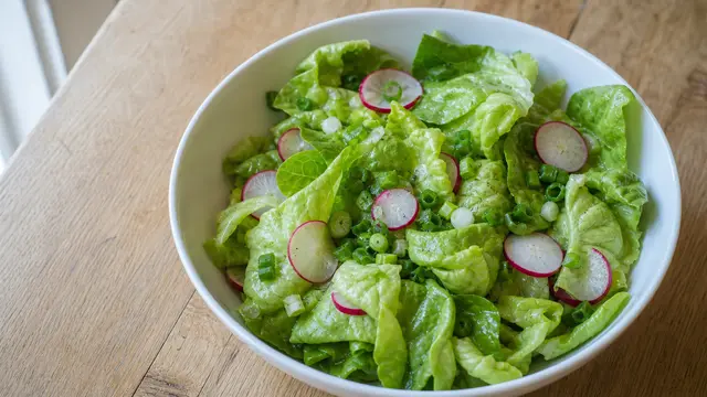 Grüner Salat mit Essig-Öl auf einem Teller