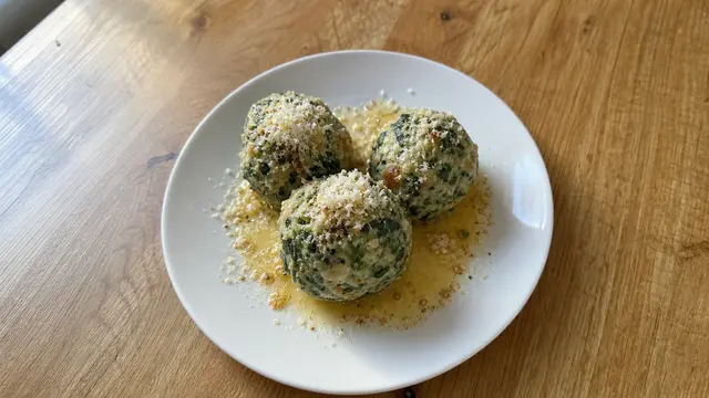 Spinatknödel mit brauner Butter auf einem Teller